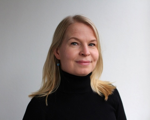 Kuvassa Jotpan projektipäällikkö Milma Arola seisoo harmaata taustaa vasten.
