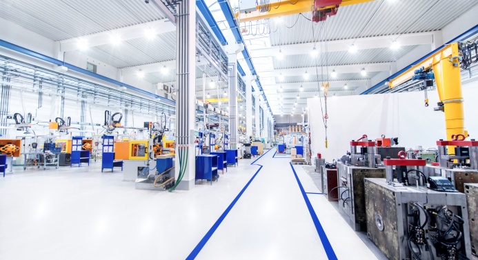 Näkymä isosta valaistusta teollisuushallista.