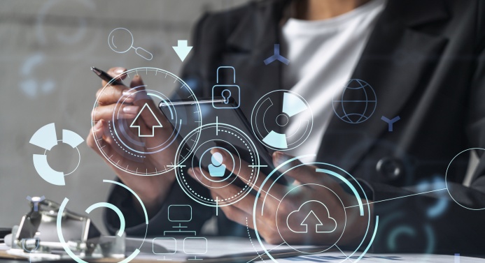 Henkilöllä kädessä puhelin ja kynä sekä pöydällä muistilehtiö, etualalla erilaisia symboleita